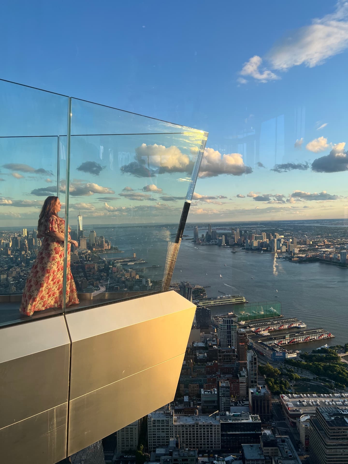 Rebecca Smith standing on a glass-walled observation deck above a city skyline
